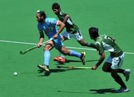 Captain Sadar Singh of India (left) runs through Muhammad Waqas and Haseem Abdul Khan of Pakistan